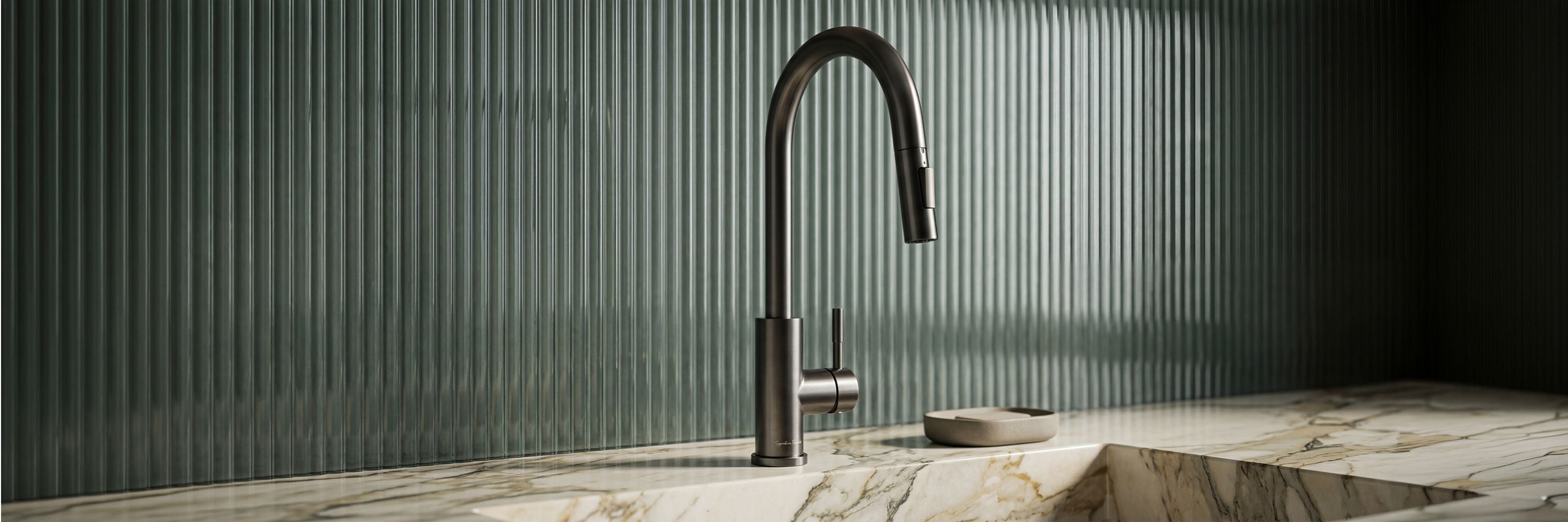 Imperium touch control pull-out kitchen faucet in Gunmetal Gray mounted on a marble countertop with a green fluted tile backsplash