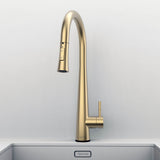 Front view of Arcus Touch Kitchen Faucet with Pull-Down Sprayer in brushed gold finish, installed on stainless steel sink by Signature Faucets. #color_brushed gold