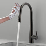 Touch-activated Arcus Kitchen Faucet with Pull-Down Sprayer in gunmetal gray finish — hands-free operation shown as soapy hands activate water flow by Signature Faucets. #color_gunmetal gray