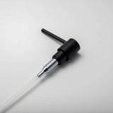 A stainless steel kitchen sink soap dispenser with a clear container and a matte black finish