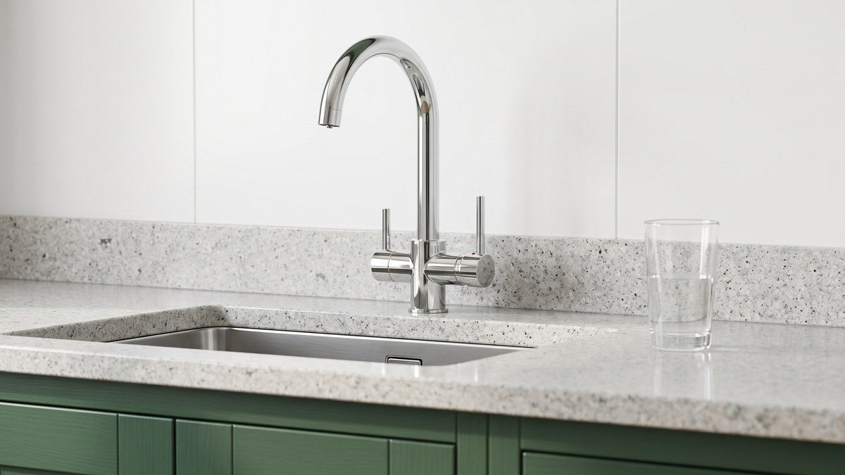Chrome Andre three way drinking tap with its two separate handles on a speckled granite counter above a stainless sink, a glass of water alongside