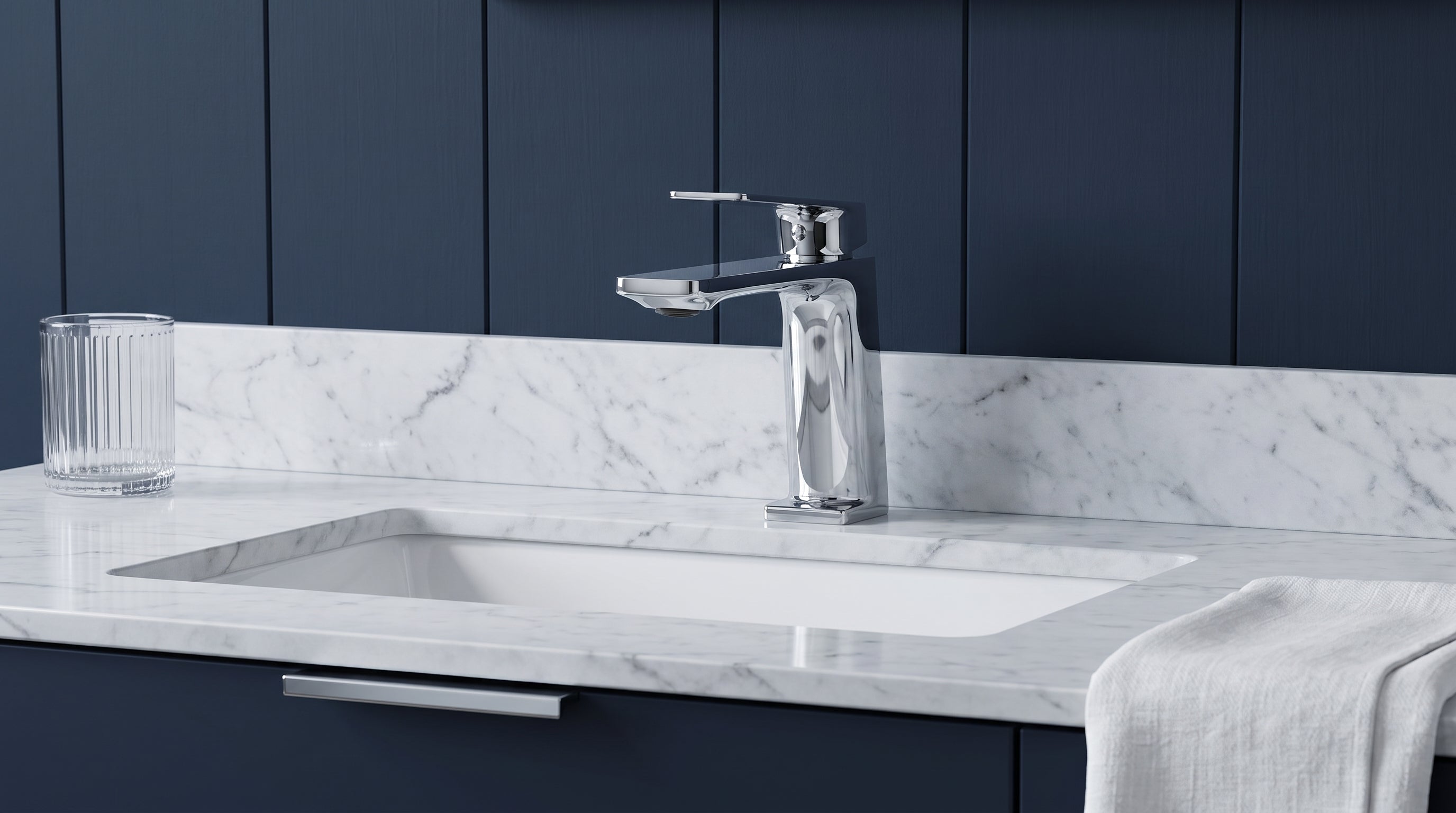 Drexler single hole bathroom faucet in chrome on a white marble vanity against deep navy panelling