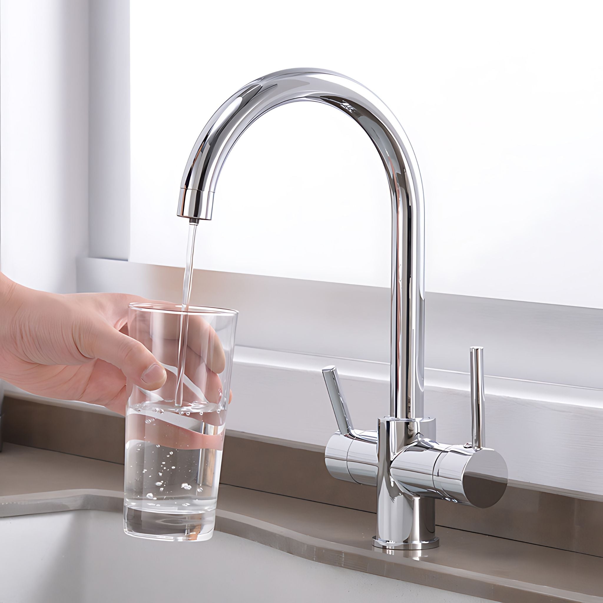 A high-arc chrome kitchen faucet with a side lever handle, shown with water running into a clear glass held by a person's hand at a sink. #color_chrome