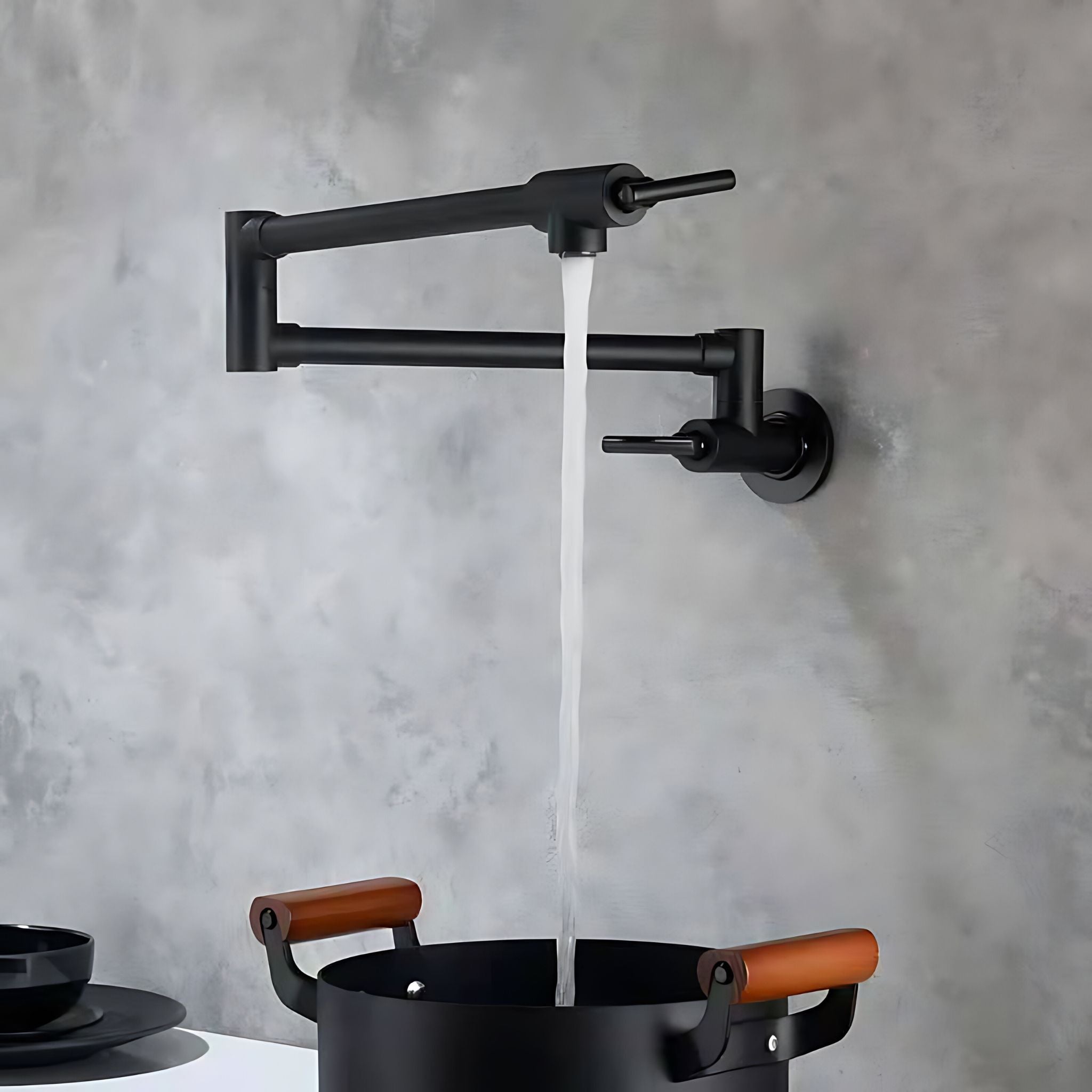 A matte black wall-mounted double-handle faucet with a stream of water flowing into a black pot with brown handles, set against a textured gray concrete wall. #color_matte black