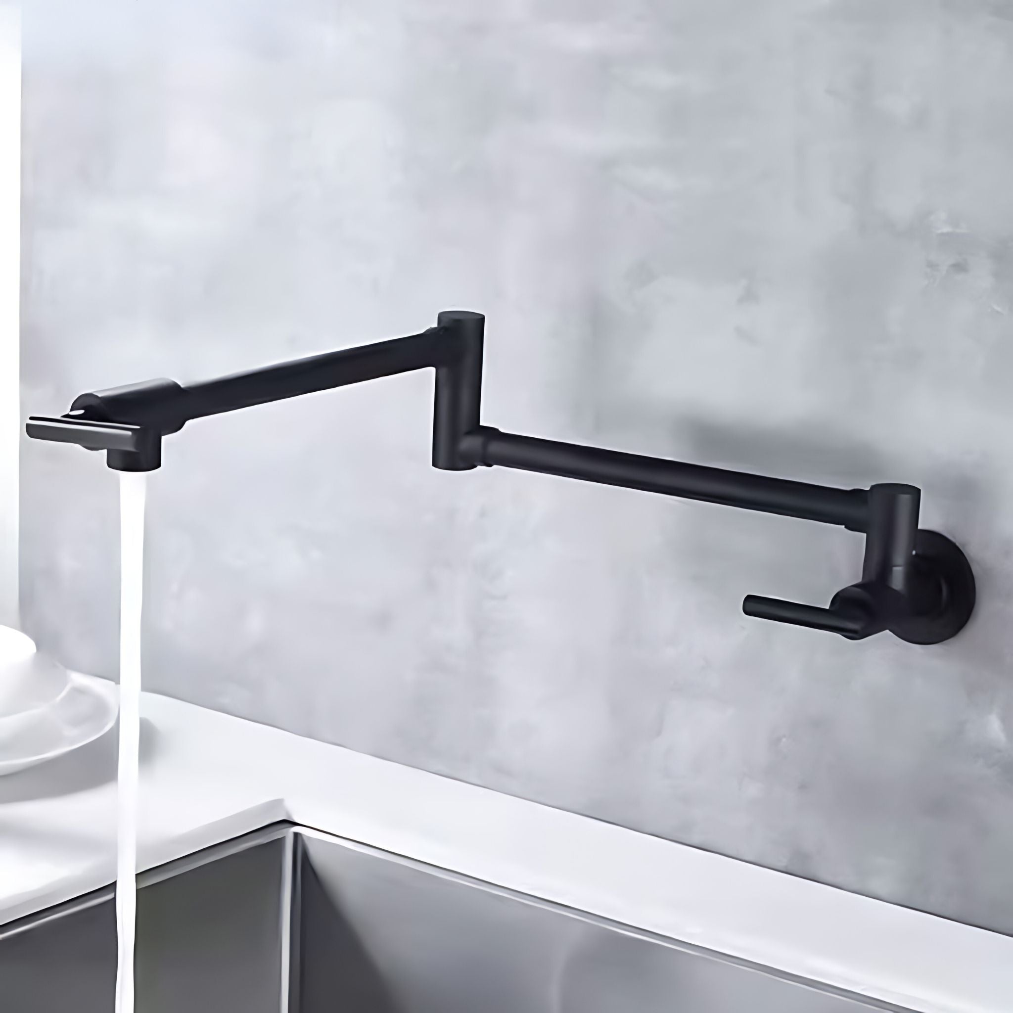 A matte black wall-mounted kitchen faucet with an adjustable arm and waterfall spout, shown installed above a sink with water running. #color_matte black