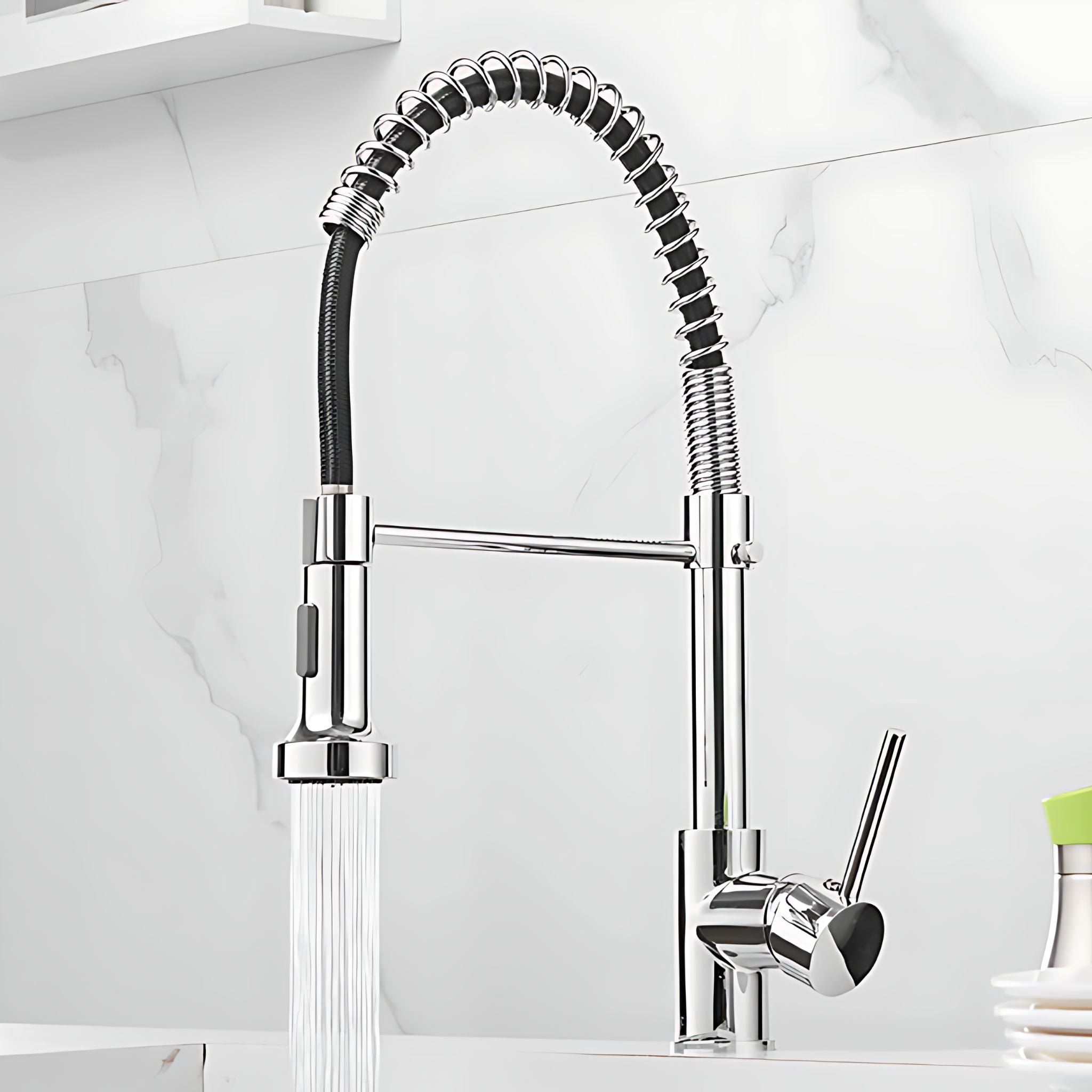 A modern chrome kitchen faucet with a flexible black-and-silver coiled sprayer and a single lever handle, shown with water running from the lower spout against a white marble backsplash. #color_chrome
