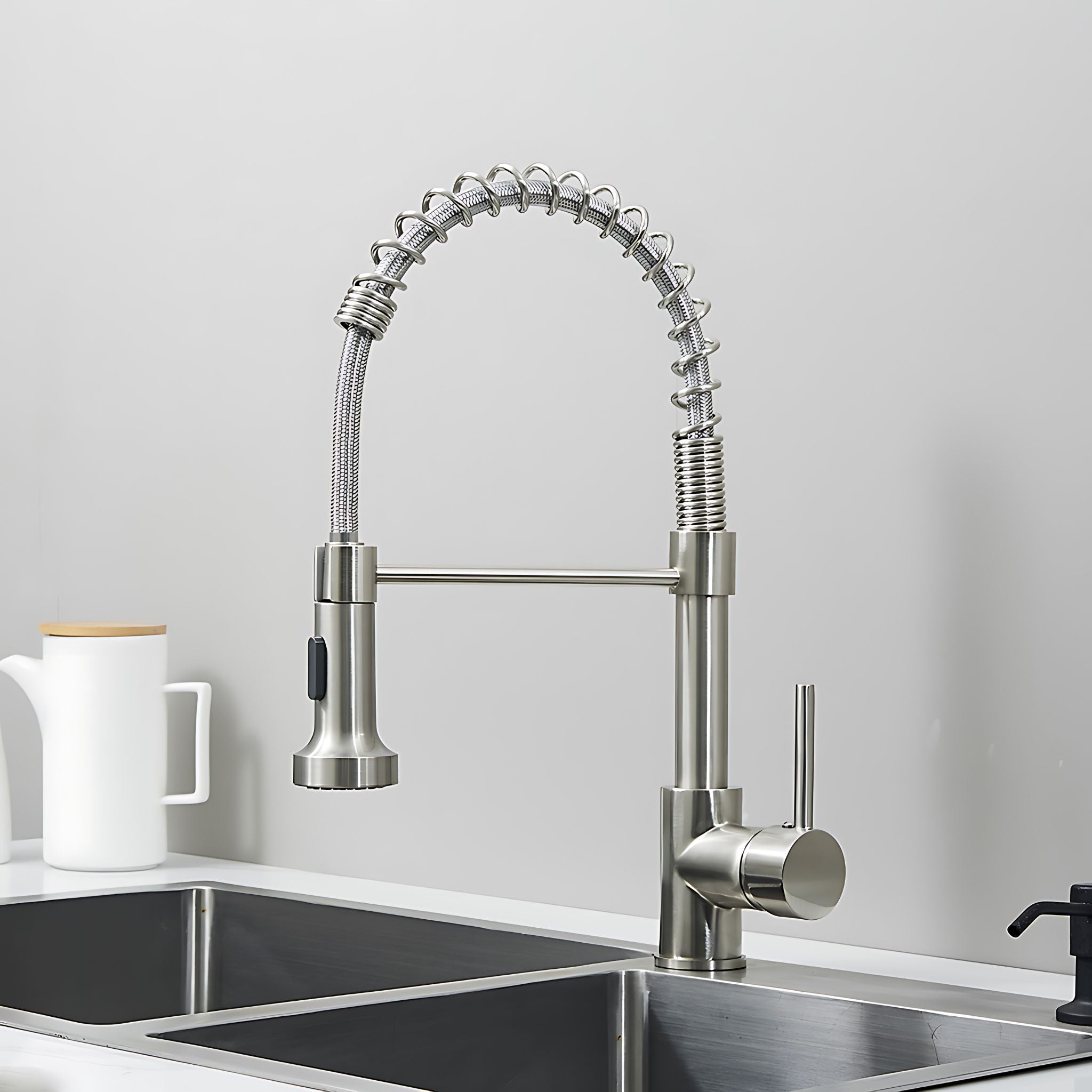Stainless steel kitchen faucet over a sink with a neutral background. #color_brushed nickel