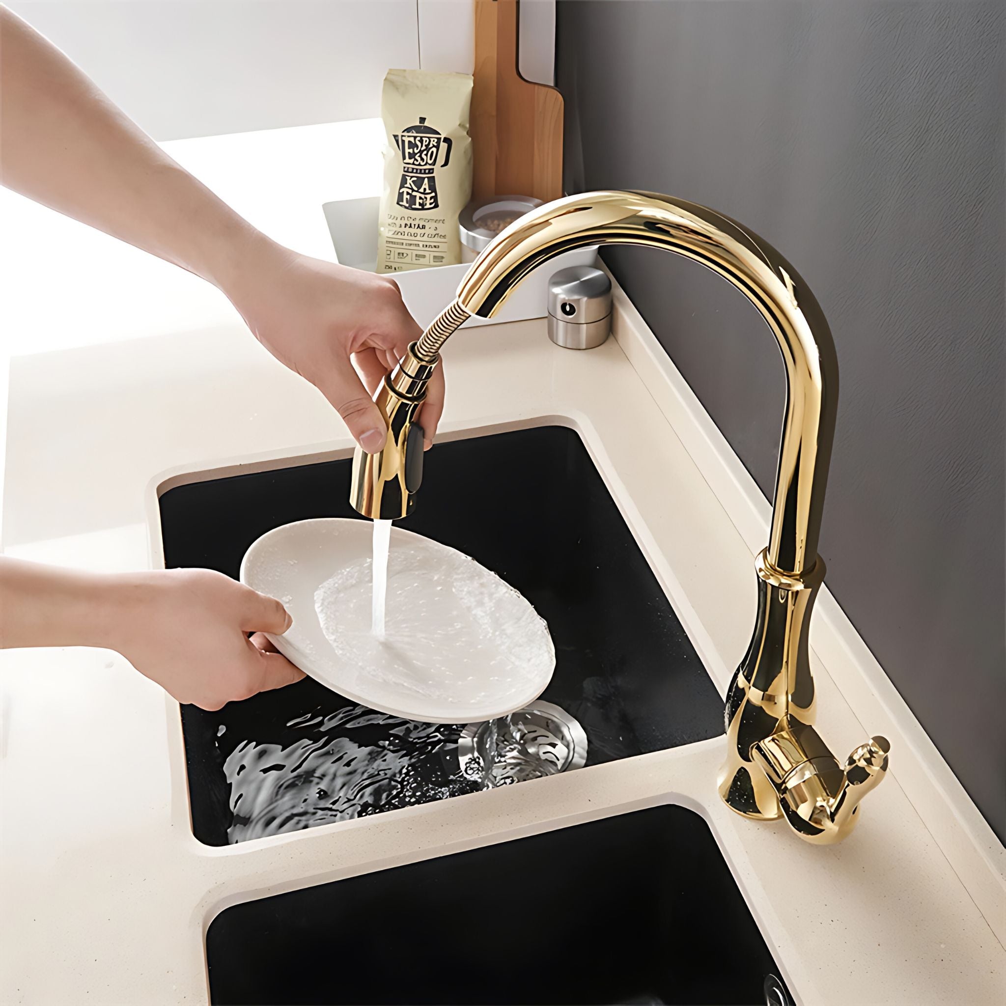 Person washing a plate under a gold faucet in a kitchen sink. #color_gold