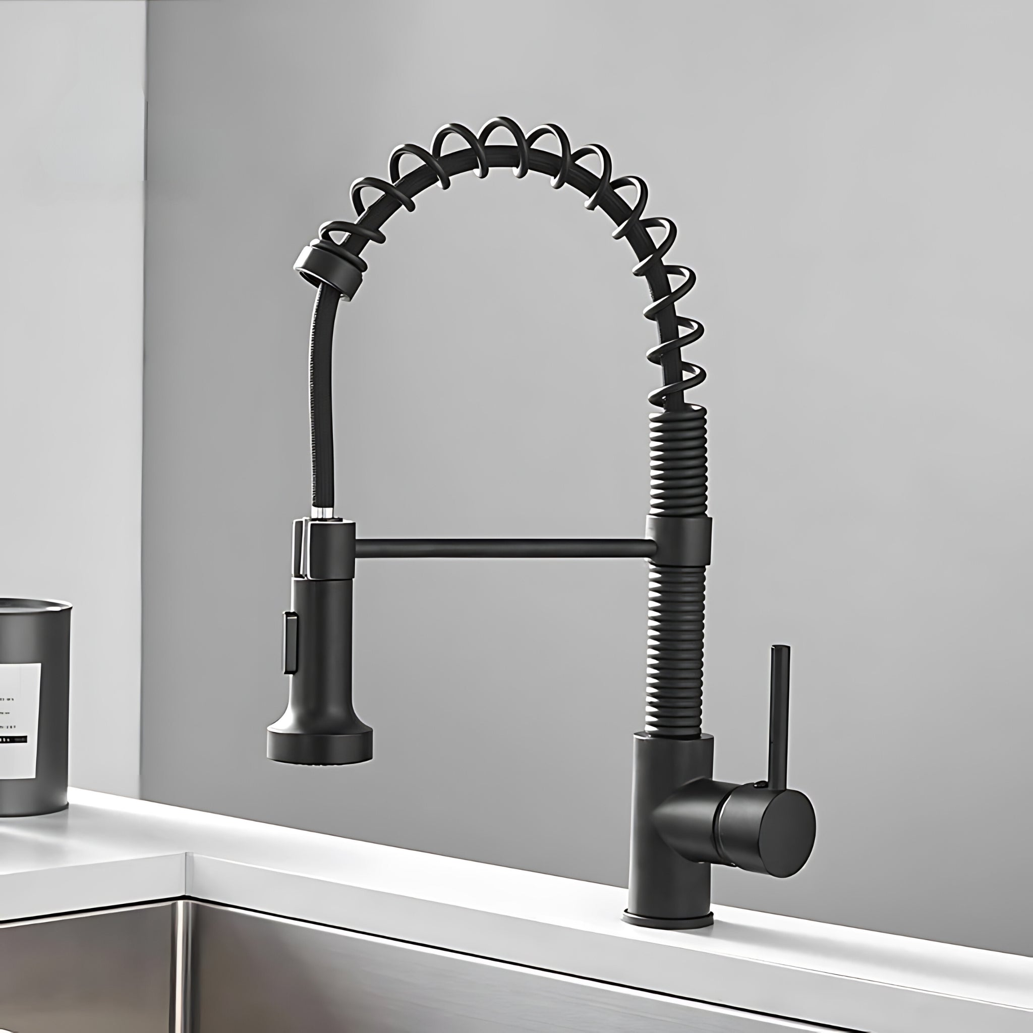 Spiro v2.0 matte black spring spout kitchen faucet installed on a countertop above a stainless steel sink #color_matte black